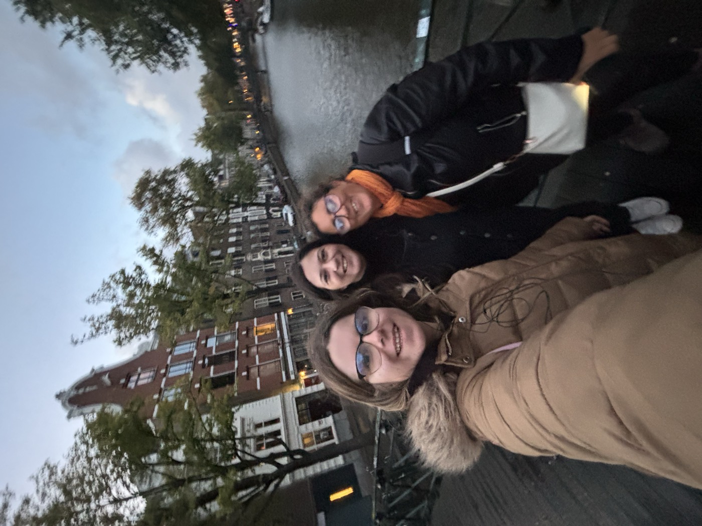 Selfie de viajantes numa ponte sobre um canal de Amesterdão