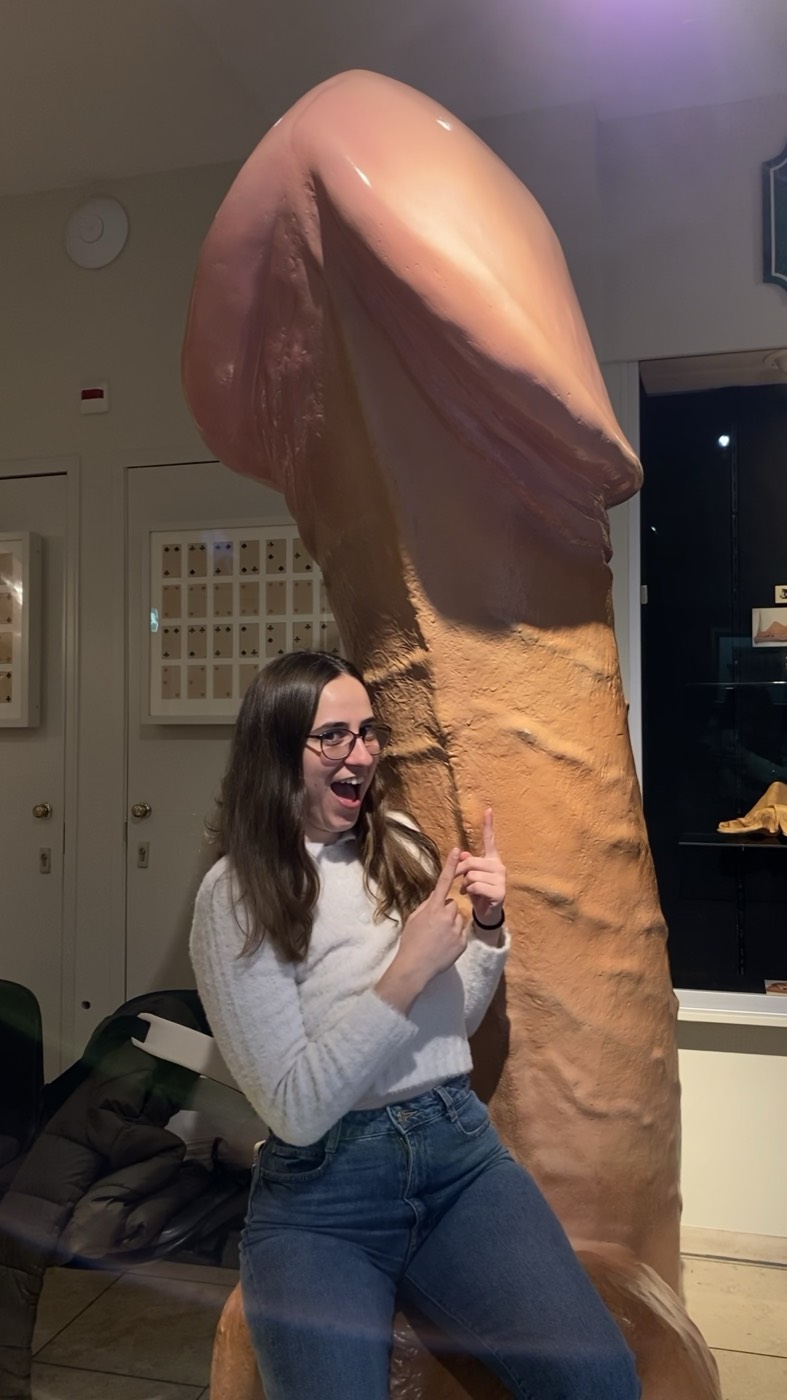 Viajante a apontar para uma escultura gigante de um pénis no Museu do Sexo