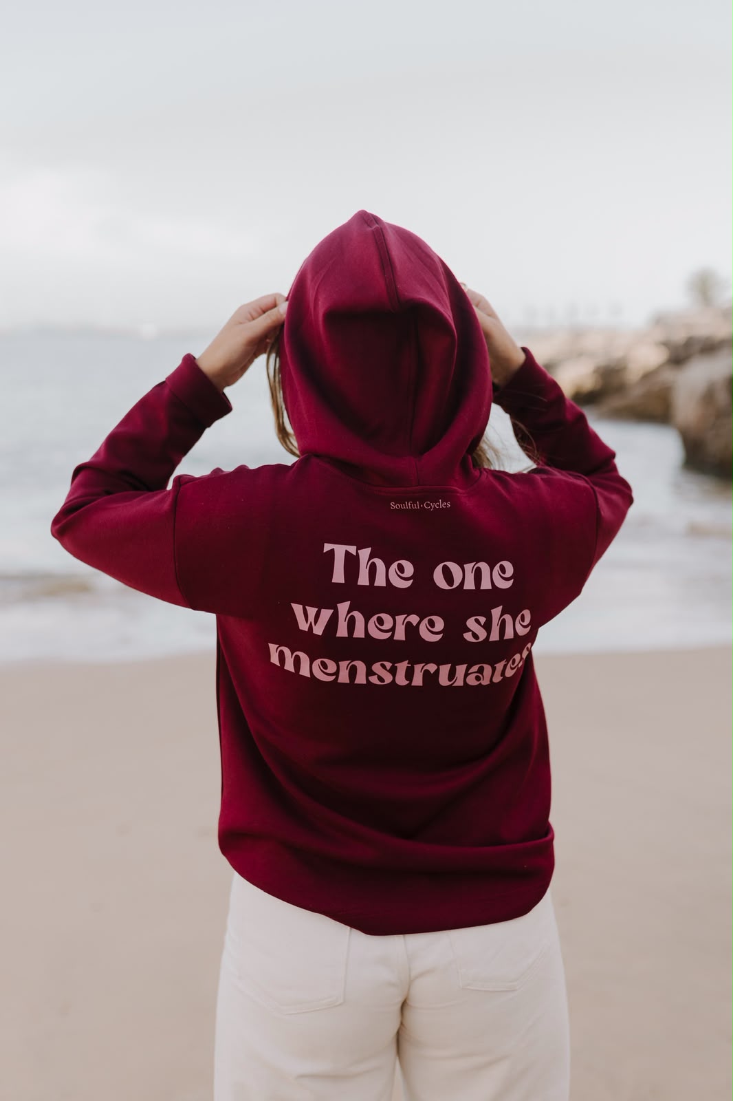 Costas de uma hoodie bordô com a frase 'The one where she menstruates'
