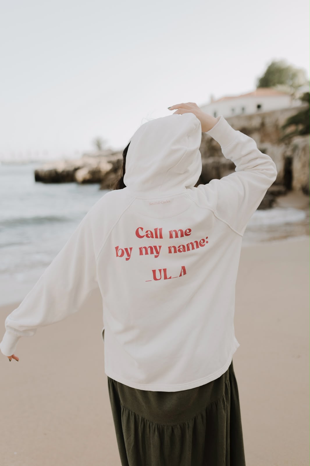 Costas de uma hoodie creme com a frase 'Call me by my name: _UL_A'