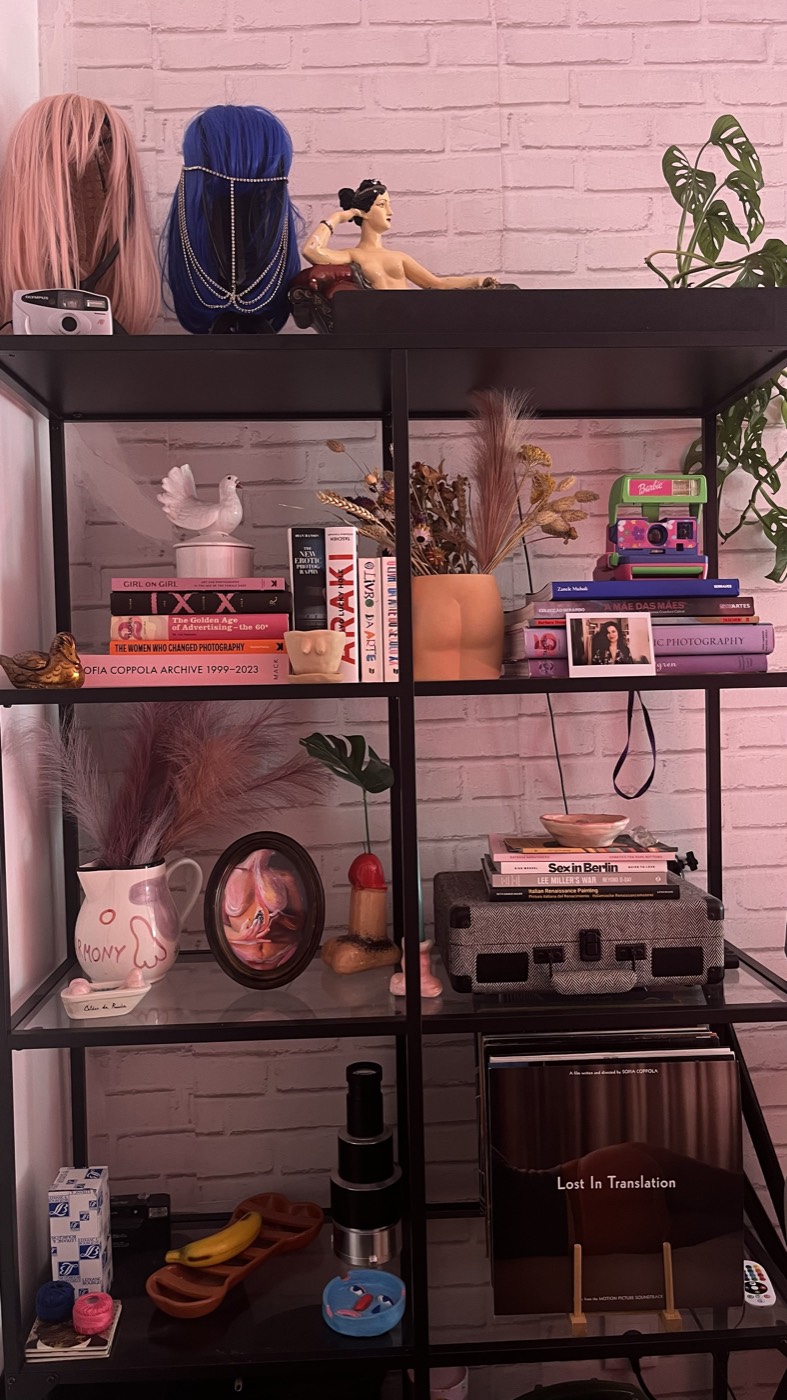 Estante com adereços, livros e uma câmara no estúdio da sessão boudoir