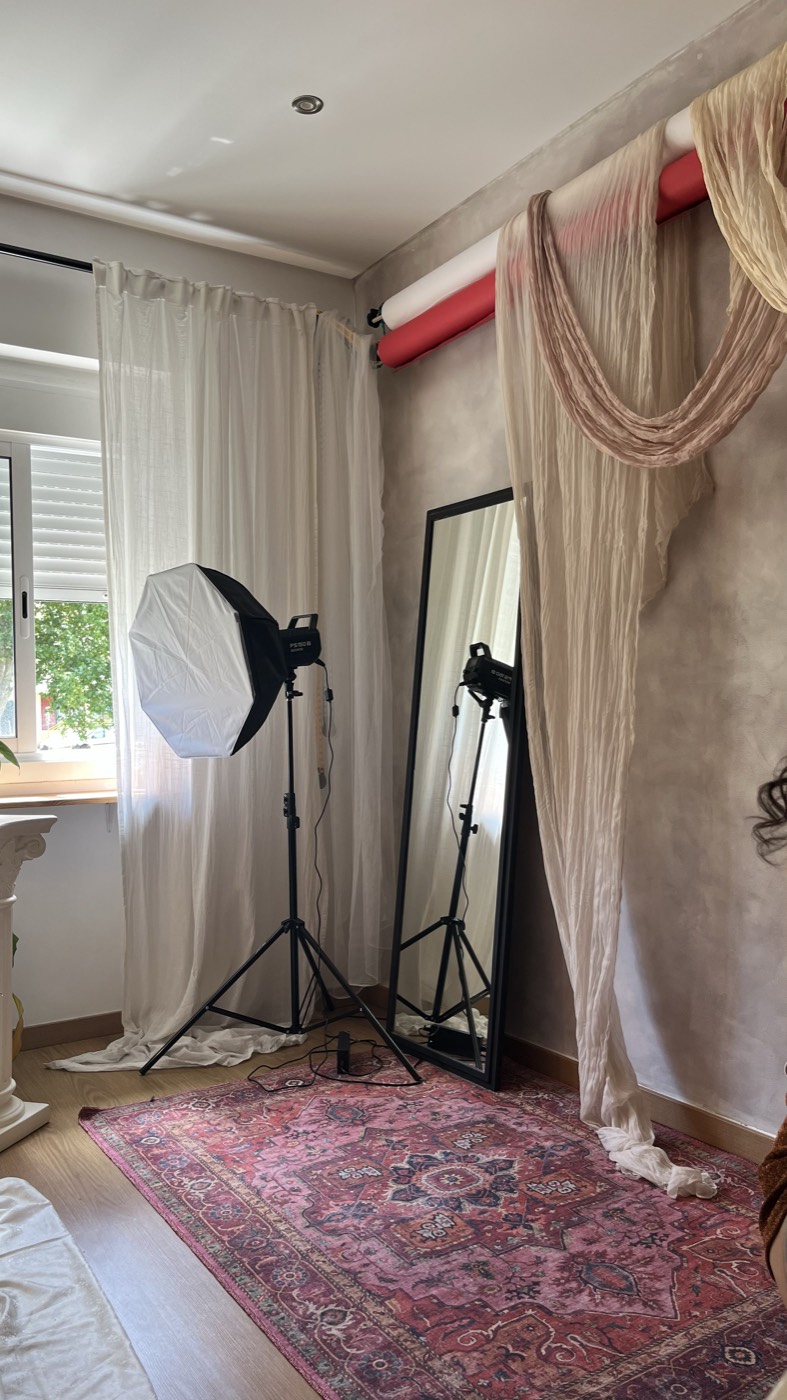 Estúdio fotográfico com luzes, um espelho grande e um tapete, pronto para uma sessão boudoir