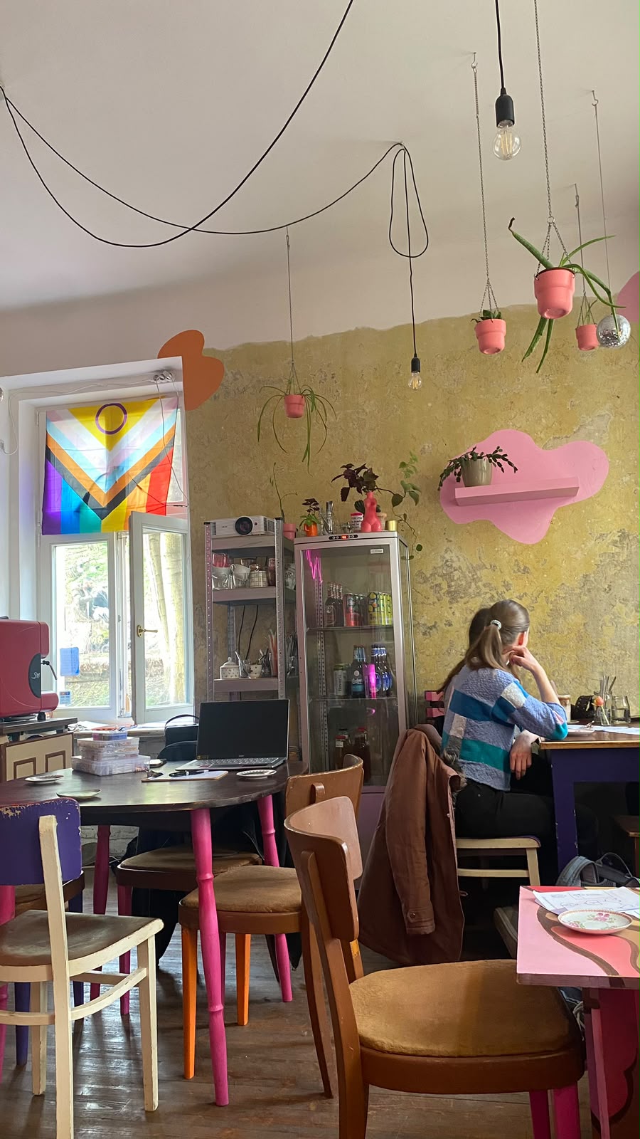Café colorido com a bandeira Progress Pride intersexo-inclusiva na montra