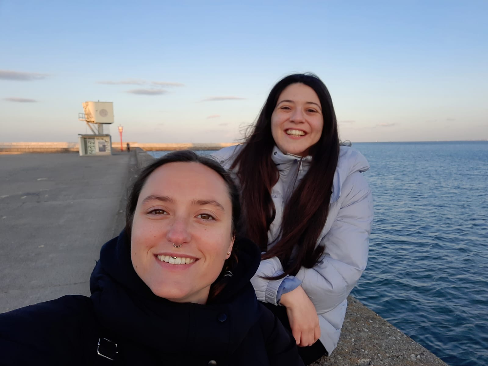 Mariana e uma amiga a sorrir numa selfie no paredão junto ao mar, em Gdynia